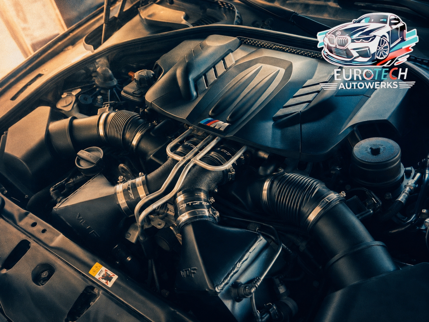 Eurotech technician working on a BMW M V8 engine bay
